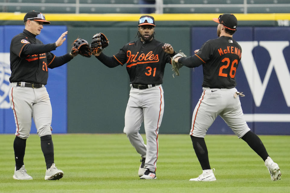 Baltimore Orioles center fielder Cedric Mullins, center, celebrates with left fielder Austin Hays, left, and right fielder Ryan McKenna after they defeated the Chicago White Sox in a baseball game in Chicago, Sunday, April 16, 2023. (AP Photo/Nam Y. Huh)