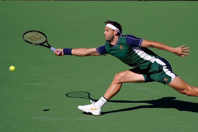 Grigor Dimitrov stretches for a forehand