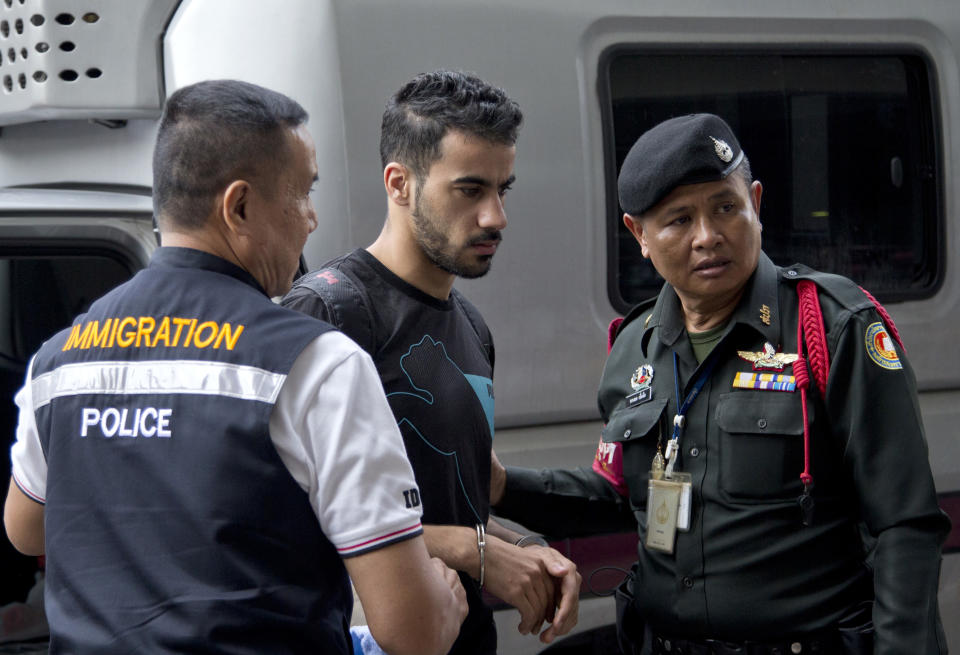 Bahraini football player Hakeem al-Araibi, center, is brought in to a court in Bangkok, Thailand, Tuesday, Dec. 11, 2018. A Thai court has ruled that the soccer player who holds refugee status in Australia can be held for 60 days pending the completion of an extradition request by Bahrain, the homeland he fled four years ago on account of alleged political persecution. (AP Photo/Gemunu Amarasinghe)