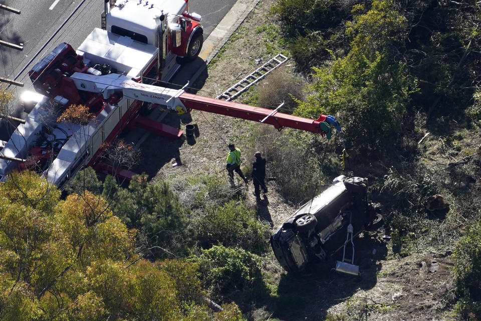 A crane is used to lift a vehicle following a rollover accident involving golfer Tiger Woods in Rancho Palos Verdes, Calif., on Feb. 23, 2021.<span class="copyright">Mark J. Terrill—AP</span>