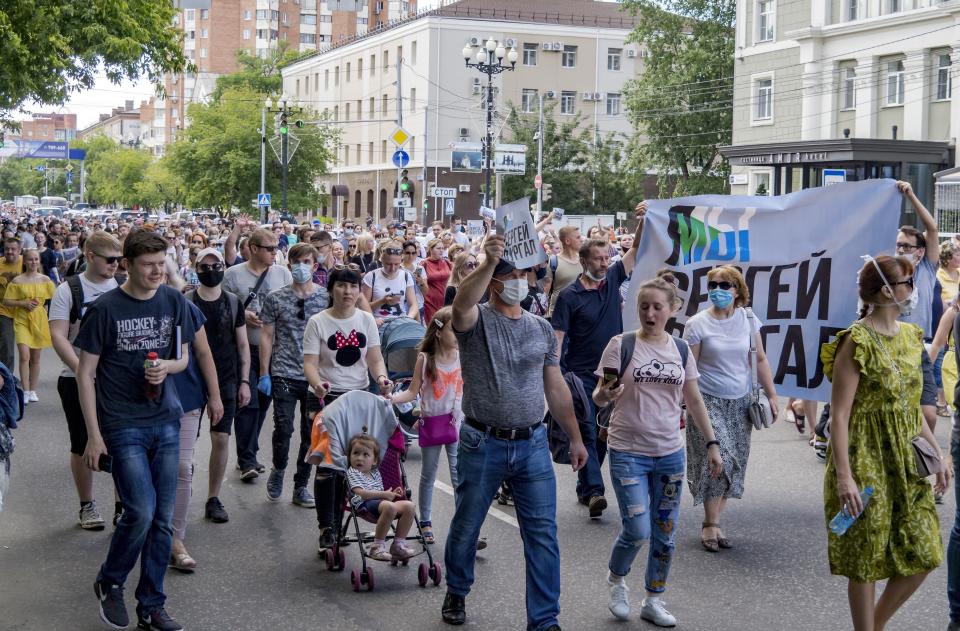 People hold posters reading "I'm, we're Sergei Furgal" during an unsanctioned protest in support of Sergei Furgal, the governor of the Khabarovsk region, who was interrogated ordered held in jail for two months, in Khabarovsk, 6100 kilometers (3800 miles) east of Moscow, Russia, Saturday, July 11, 2020. Thousands of demonstrators in the Russian Far East city of Khabarovsk held a protest against the arrest of the region's governor on charges of involvement in multiple murders. Local news media gave estimates of the crowd ranging from 5,000 to 35,000. (AP Photo/Igor Volkov)