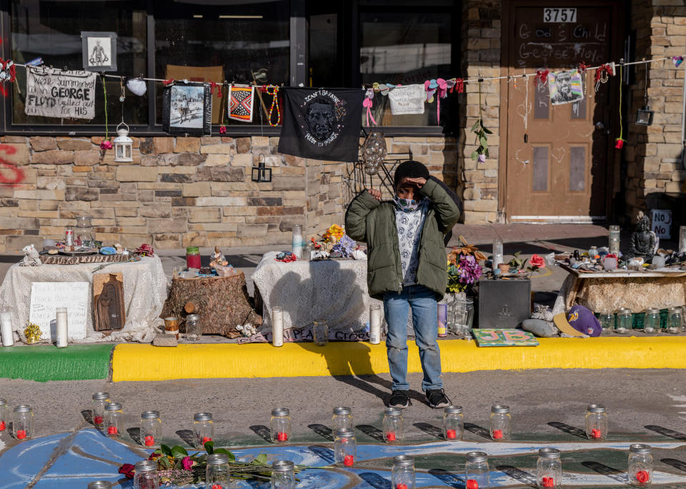 Jamal Ford, 5, visits the George Floyd memorial with his father, Jerome Ford, in April. While looking at the painted outline of Floyd's body, Ford offered a salute.<span class="copyright">Ruddy Roye for TIME</span>