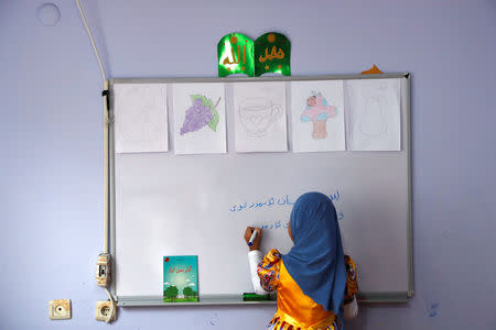 A girl writes, 'We, children of Turkestan, love our homeland' in the Uighur language in a classroom at a kindergarten for Uighur children in the Zeytinburnu district, which hosts most of the Uighur exiles, in Istanbul, Turkey, December 14, 2018. REUTERS/Murad Sezer