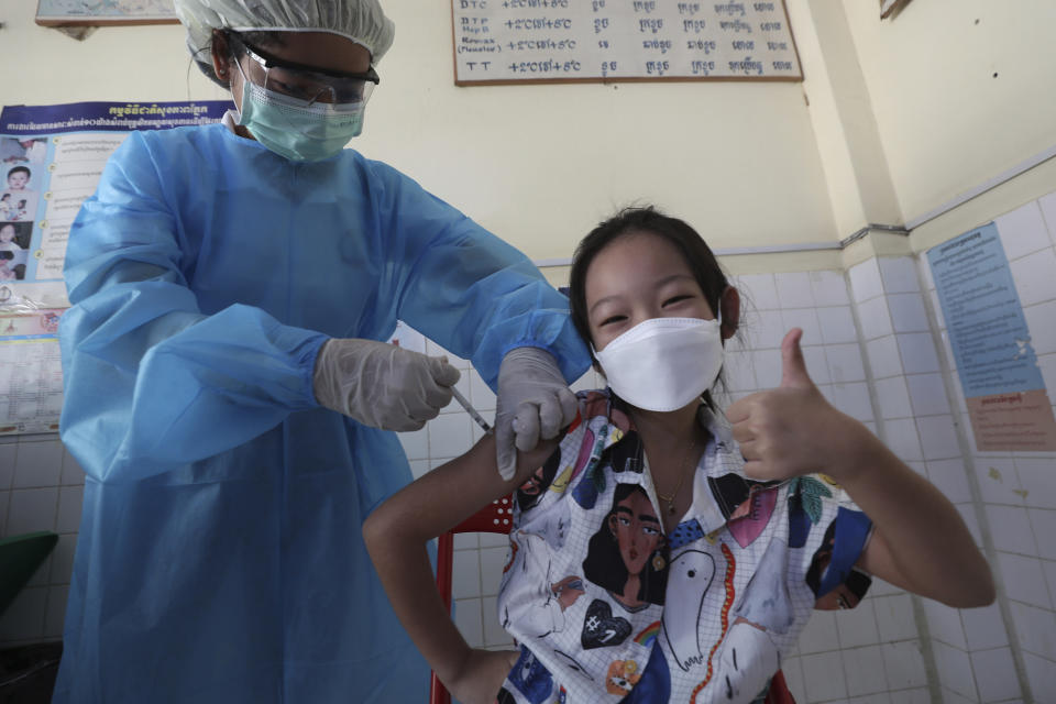 A young girl thumbs up as she receives a shot of the Sinovac's COVID-19 vaccine at a Samrong Krom health center outside Phnom Penh, Cambodia, Friday, Sept. 17, 2021. Prime Minister Hun Sen announced the start of a nationwide campaign to give COVID-19 vaccinations to children between the ages of 6 and 11 so they can return to school safely after a long absence due to measures taken against the spread of the coronavirus. (AP Photo/Heng Sinith)