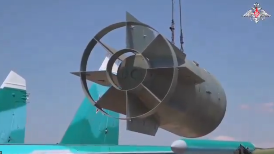 A screencap from the new video shows a FAB-3000 being transported toward a Su-34, before the UMPK kit has been fitted. <em>Russian MoD</em>