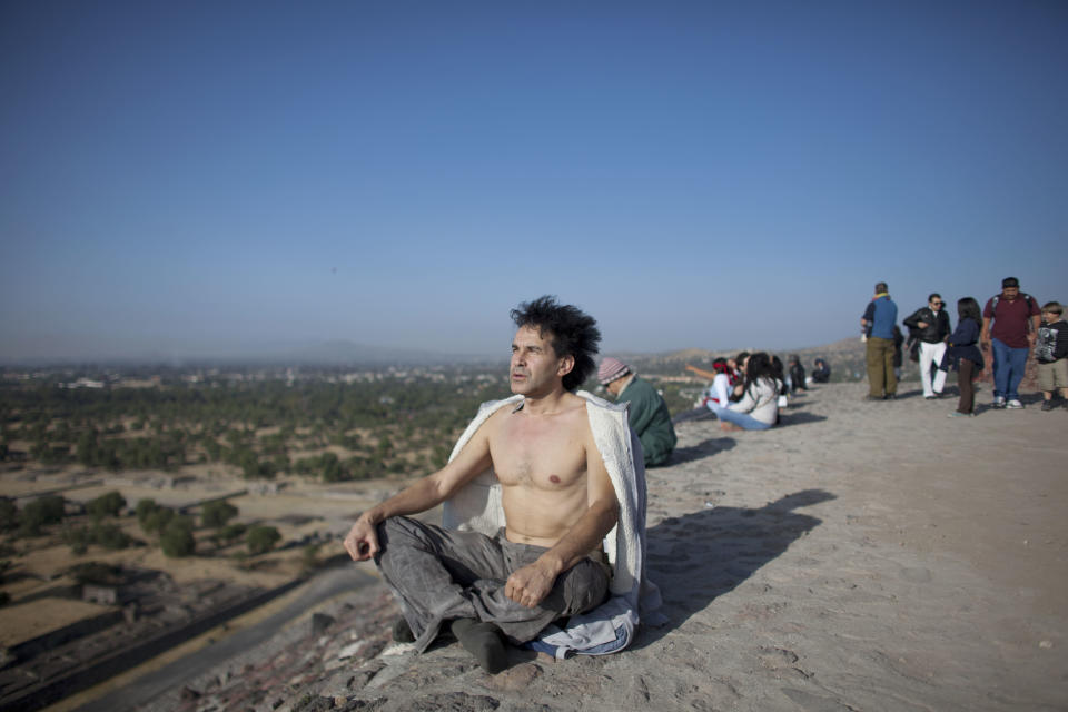 A man meditates from the top of the Pyramid of the Sun as the sun rises at the Teotihuacan archeological site in Teotihuacan, Mexico, Friday, Dec. 21, 2012. Many believe today is the conclusion of a vast, 5,125-year cycle in the Mayan calendar. Some have interpreted the prophetic moment as the end of the world, while others as believed it marked the birth of a new and better age. (AP Photo/Alexandre Meneghini)