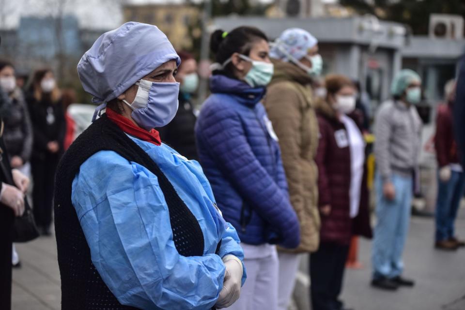 Turkish health workers join in a moment of silence in front of a hospital building in Istanbul on April 2.