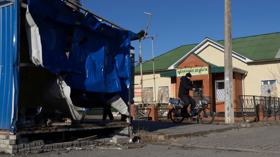 A man rides a bicycle near a damaged market pavilion hit by recent shelling in the town of Shebekino in the Belgorod region of Russia on March 11. - Maxim Shemetov/Reuters