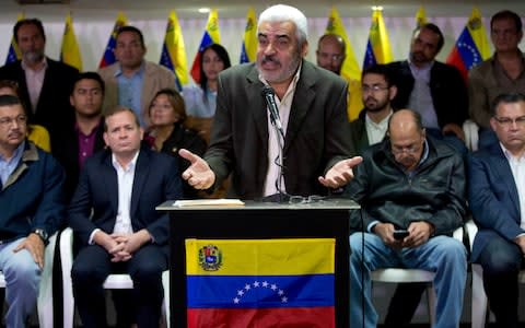 Opposition leader Angel Oropeza, accompanied by opposition members, speaks to the press in Caracas, Venezuela  - Credit:  AP