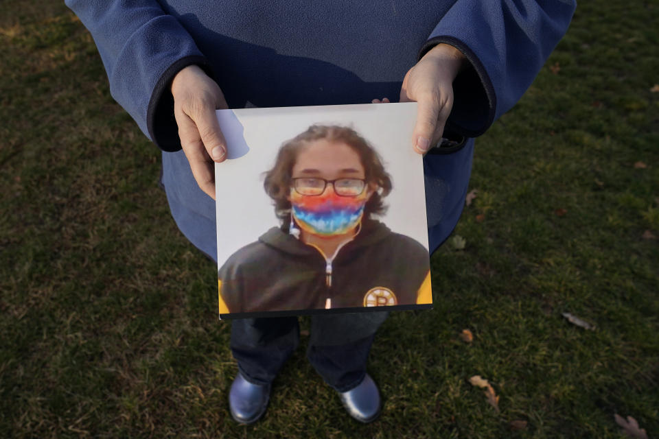 Laura Dilts, of Barre, Mass., holds a photograph of her 16-year-old son outside the Worcester Recovery Center, where he is a resident patient receiving assistance for his mental health, Monday, Nov. 23, 2020, in Worcester, Mass. The coronavirus pandemic has led to rising emergency room visits and longer waits for U.S. children and teens facing mental health issues. (AP Photo/Charles Krupa)