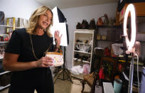 Deborah Mayer shows a bag on a livestream on TikTok on Wednesday, March 21, 2024, in Freehold, N.J. Mayer has sold new and pre-owned handbags and other designer goods out of her New Jersey home for 16 years. Early last year, TikTok recruited her business for the live component of TikTok Shop. (AP Photo/Noah K. Murray)