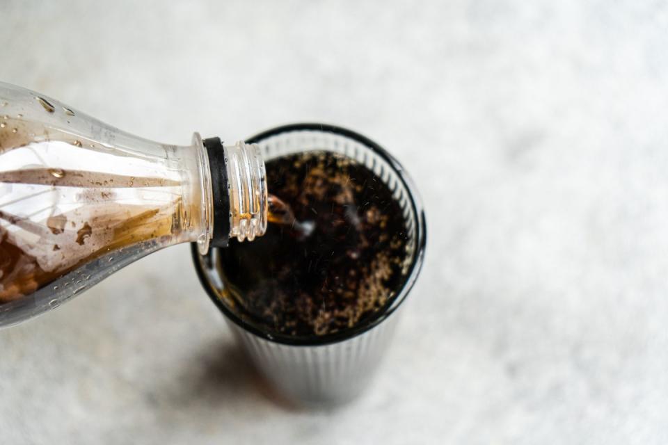 overhead view of glass of cola being poured