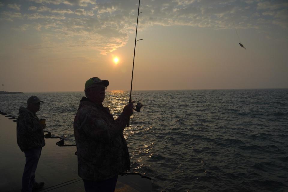 Tim Hansen of Racine prepares to cast Thursday morning while fishing for yellow perch in Lake Michigan on the South Pier in Racine.