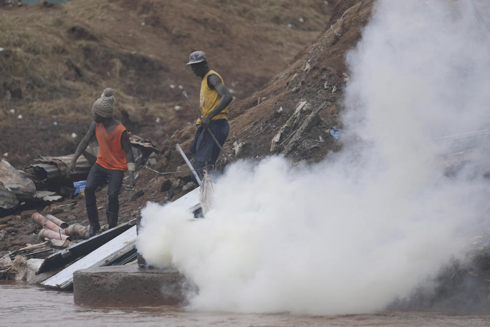 Residents are teargassed by riot police as they try to salvage material in the Mathare area of Nairobi, Kenya Wednesday, May. 8, 2024. The Kenyan government last week ordered evacuations and the demolition of structures and buildings that had been built illegally within 30 meters of river banks. But the demolitions have only led to more suffering as those affected say they are being carried out in a chaotic and inhumane way. (AP Photo/Brian Inganga)