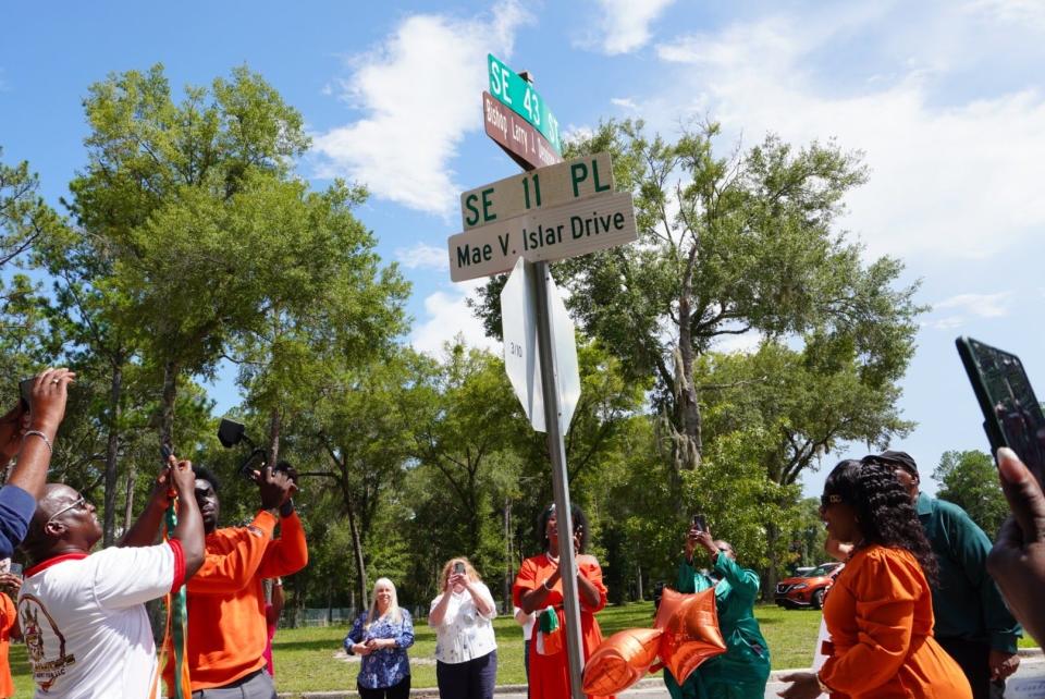 A street sign is unveiled on Saturday at Eastside High School in honor of Mae Islar, the first woman principal of the school.