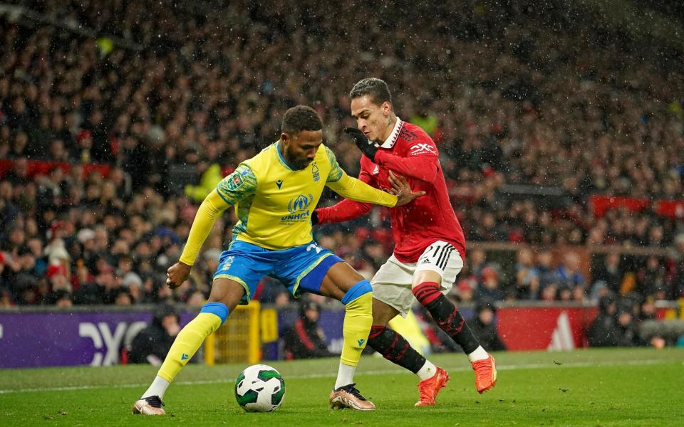 Nottingham Forest's Emmanuel Dennis, left, is challenged by Manchester United's Antony during the English League Cup semifinal second leg - AP