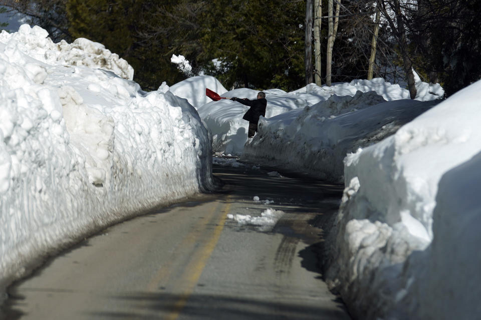 A resident clears snow from a driveway after a series of storms, Wednesday, March 8, 2023, in Lake Arrowhead, Calif. (AP Photo/Marcio Jose Sanchez)