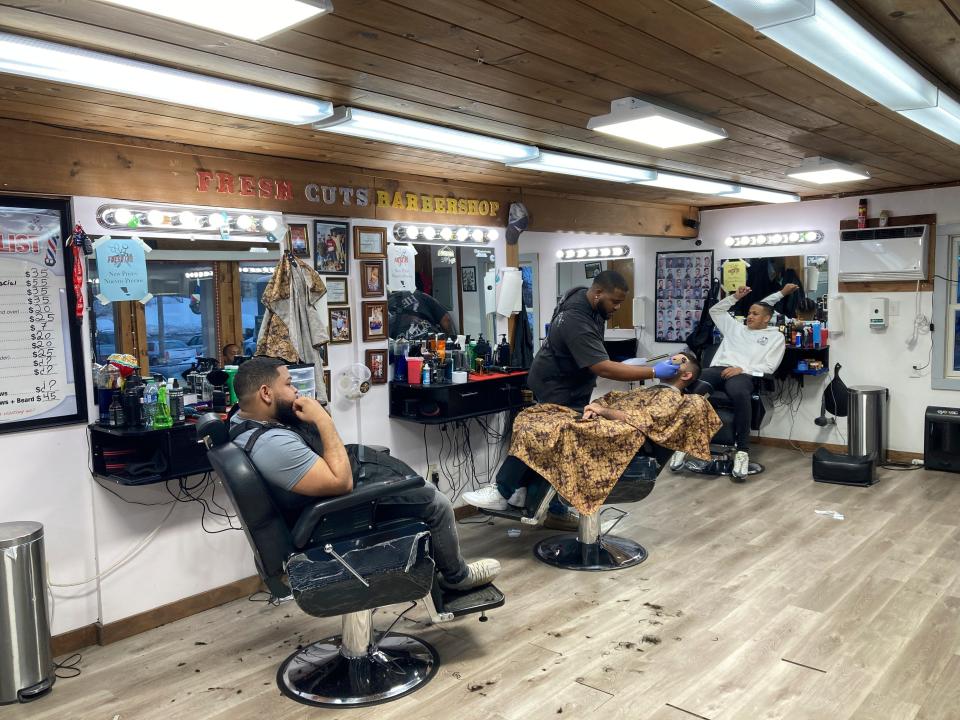 People get haircuts on Wednesday at a Leominster barbershop, where Francisco Torres walked into the shop and said he wanted someone to shoot him with an automatic weapon.