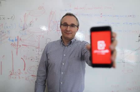 Damir Sabol, owner of software company which developed the PhotoMath application, poses with a smartphone in Zagreb February 24, 2015. REUTERS/Antonio Bronic