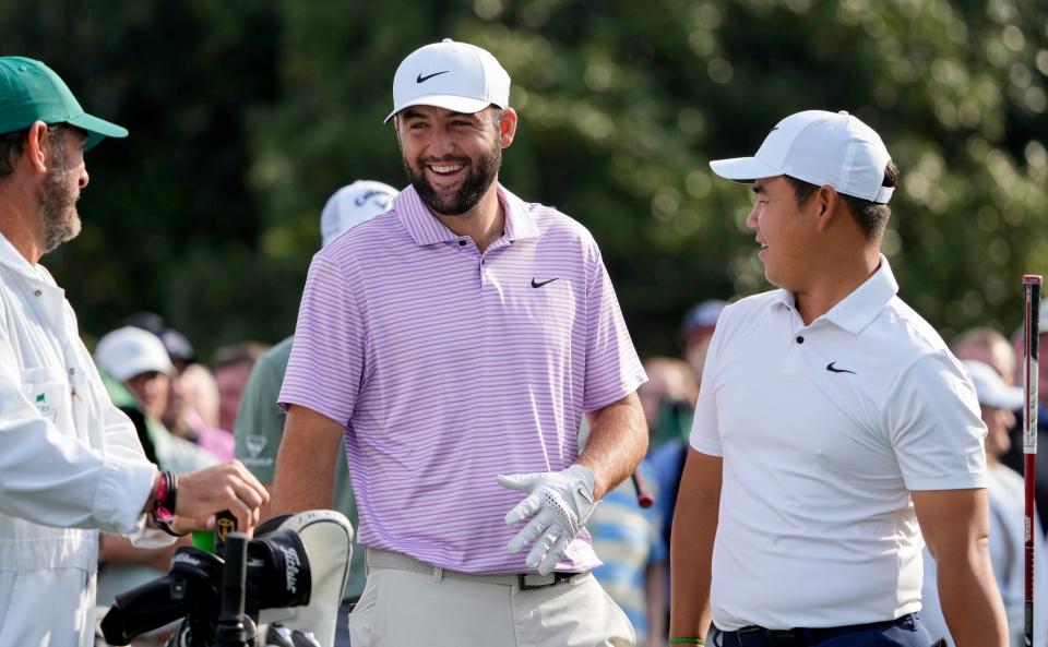 Scottie Scheffler shares a laugh with Tom Kim and his caddie Paul Tesori at the no. 10 tee during a practice round at Augusta National Golf Club.