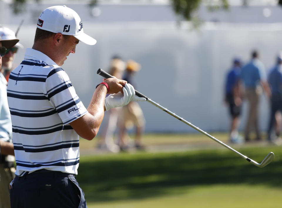 Justin Thomas examines his club after hitting from behind a tree on the 10th hole during the first round of the Honda Classic golf tournament, Thursday, Feb. 28, 2019, in Palm Beach Gardens, Fla. (AP Photo/Wilfredo Lee)