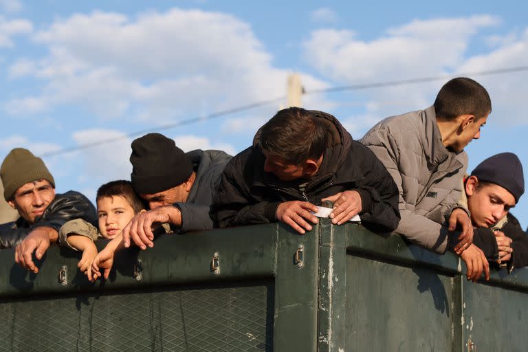 Refugiados se encuentran en la parte trasera de un camión cargado con sus pertenencias cerca de Kornidzor el 28 de septiembre de 2023.