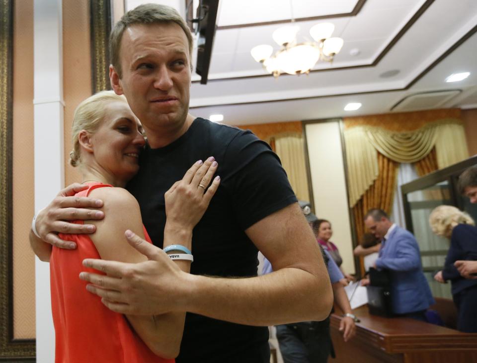 FILE- Russian opposition leader Alexei Navalny, right, embraces his wife Yulia, as he was released in a courtroom in Kirov, Friday, July 19, 2013. In a span of a decade, Navalny has gone from the Kremlin's biggest foe to Russia's most prominent political prisoner. Already serving two convictions that have landed him in prison for at least nine years, he faces a new trial that could keep him behind for another two decades. (AP Photo/Dmitry Lovetsky, file)