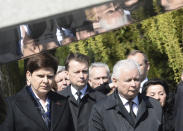 The ruling party Law and Justice leader and twin brother of the former Polish President Lech Kaczynski, Jaroslaw Kaczynski, right, Interior Minister Mariusz Blaszczak, center, and Polish Prime Minister Beata Szydlo, left, attend a ceremony at the Powazki cemetery to mark the seventh anniversary of the crash of the Polish government plane in Smolensk, Russia, that killed 96 people on board including Lech Kaczynski, in Warsaw, Poland, Monday, April 10, 2017. (AP Photo/Alik Keplicz)