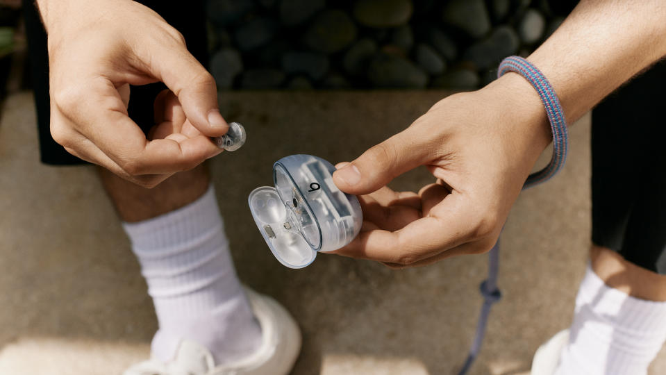 Beats Studio Buds+ in transparent being taken out of charging case