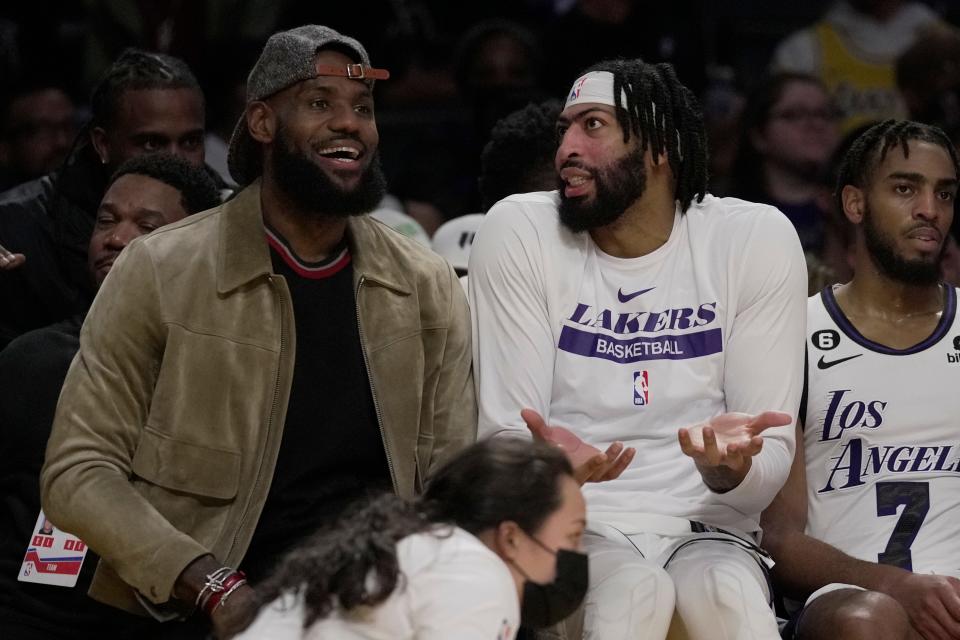 Los Angeles Lakers forward LeBron James, left, and forward Anthony Davis sit on the bench during the second half of an NBA basketball game against the Brooklyn Nets in Los Angeles, Sunday, Nov. 13, 2022. (AP Photo/Ashley Landis)