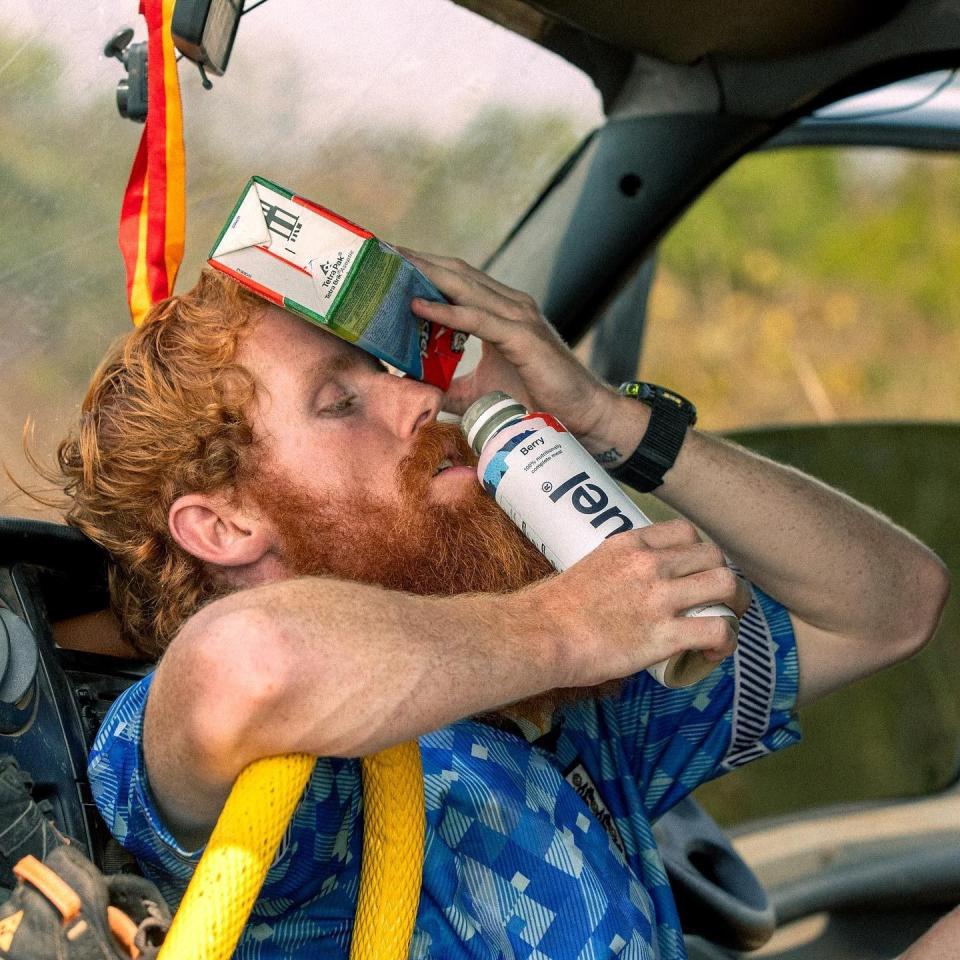 Cook holding cold bottles of drink to his head