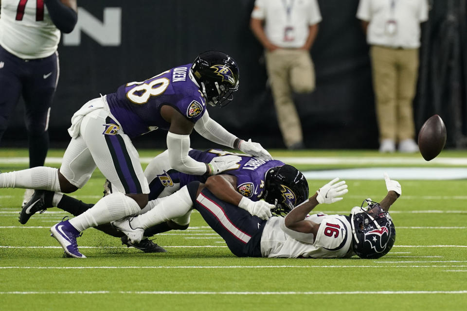 Baltimore Ravens cornerback Marlon Humphrey, center, causes Houston Texans wide receiver Keke Coutee (16) to fumble during the first half of an NFL football game Sunday, Sept.20, 2020, in Houston. Baltimore recovered the ball and scored a touchdown on the play. (AP Photo/David J. Phillip)