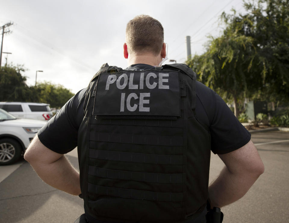 FILE - In this July 8, 2019, file photo, a U.S. Immigration and Customs Enforcement (ICE) officer looks on during an operation in Escondido, Calif. International students will be forced to leave the U.S. or transfer to another college if their schools offer classes entirely online this fall, under new guidelines issued Monday by federal immigration authorities. The guidelines, issued by U.S. Immigration and Customs Enforcement, provide additional pressure for campuses to reopen even amid growing concerns about recent spread of COVID-19 among young adults. (AP Photo/Gregory Bull, File)