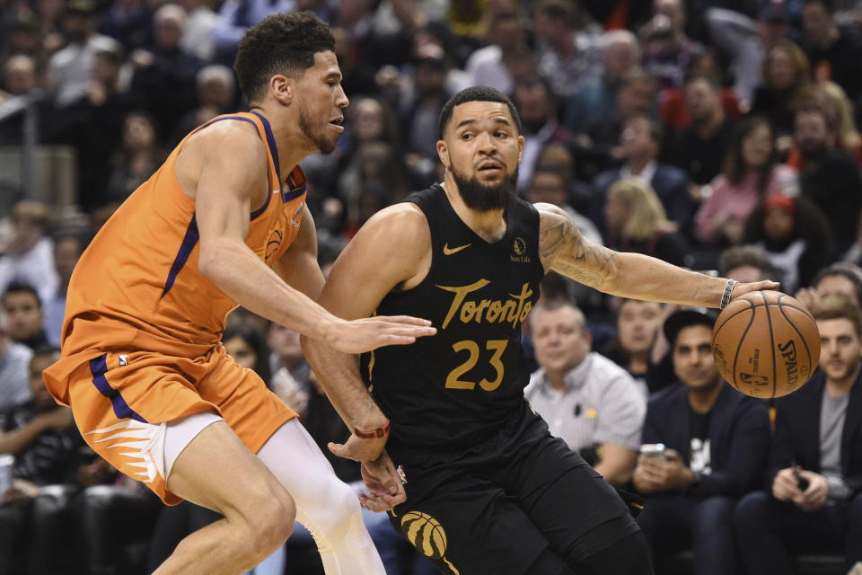 Toronto Raptors guard Fred VanVleet (23) controls the ball as Phoenix Suns guard Devin Booker (1) defends during the second half of an NBA basketball game Friday, Feb. 21, 2020, in Toronto. (Frank Gunn/The Canadian Press via AP)