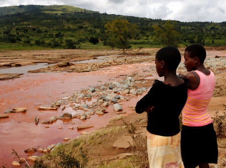 Survivors look at the site of a bridge that was washed away by Cyclone Idai at Peacock Growth Point in Chimanimani, Zimbabwe March 22, 2019. REUTERS/Philimon Bulawayo