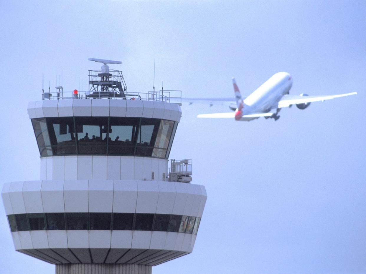 A plane takes off in front of the control tower at Gatwick Airport.