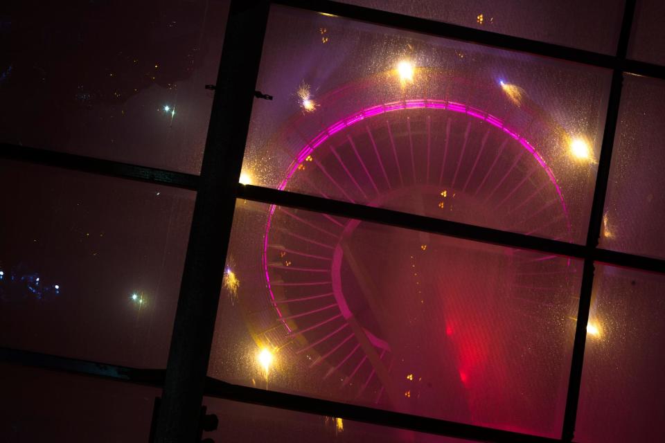 Colorful bursts of fireworks explode along the 605-foot height of the Space Needle during the "T-Mobile New Year’s Eve at the Needle" event Wednesday, Jan. 1, 2014, as seen from the Dale Chihuly Garden and Glass Museum at the Seattle Center in Seattle, Wash. The show lasted eight minutes in total, and for the first time ever, was set to a musical score of contemporary pop, rock and hip hop instead of classical. (AP Photo/seattlepi.com, Jordan Stead)