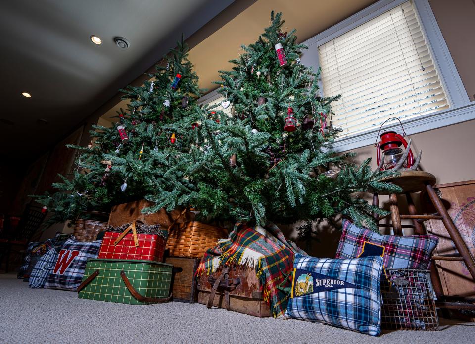 Three faux trees are surrounded by pillows made by Julie Hunt in her home's rec room.