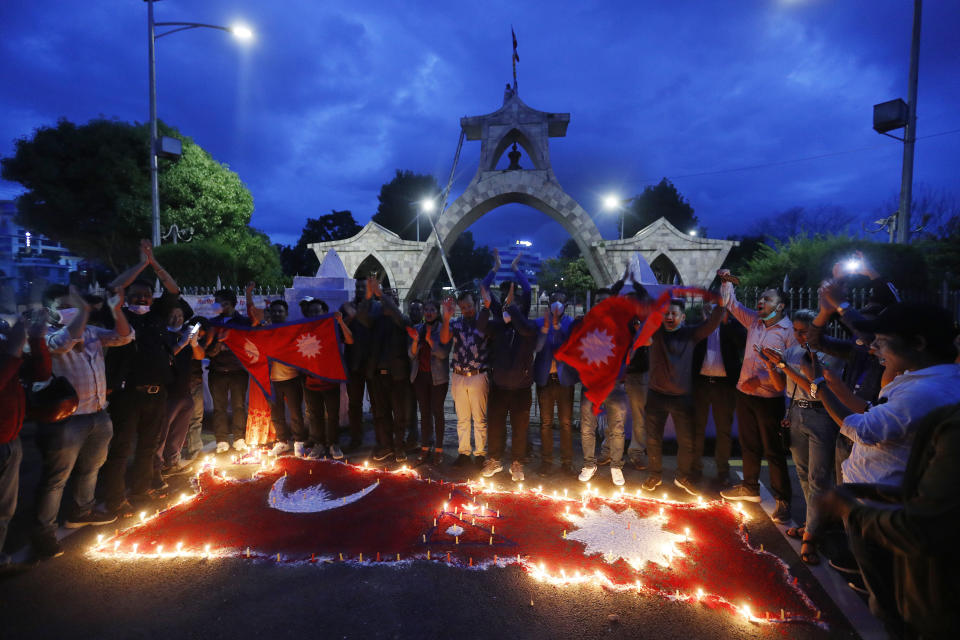 People light candles on an outline of the new map of Nepal drawn on a road as they celebrate the approval of the political map to include territory claimed by both India and Nepal, in Kathmandu, Nepal, Saturday, June 13, 2020. Nepal’s Parliament on Saturday overwhelmingly approved the constitutional amendment to change the nation’s political map. The voting follows the government's issuing of a new map last month that showed the disputed territory within its borders. (AP Photo/Niranjan Shrestha)