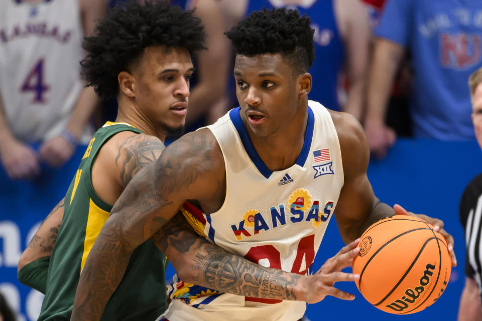 Baylor forward Jalen Bridges, left, tries to steal the ball from Kansas forward K.J. Adams Jr. (24) during the second half of an NCAA college basketball game in Lawrence, Kan., Saturday, Feb. 10, 2024. (AP Photo/Reed Hoffmann)