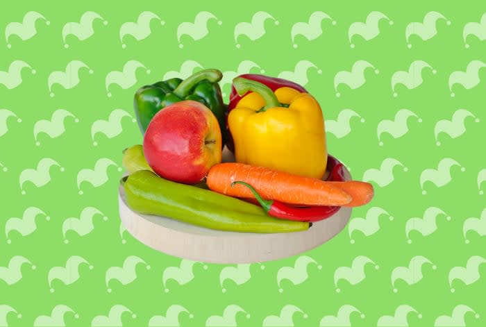 Some fruits and vegetables against a green background