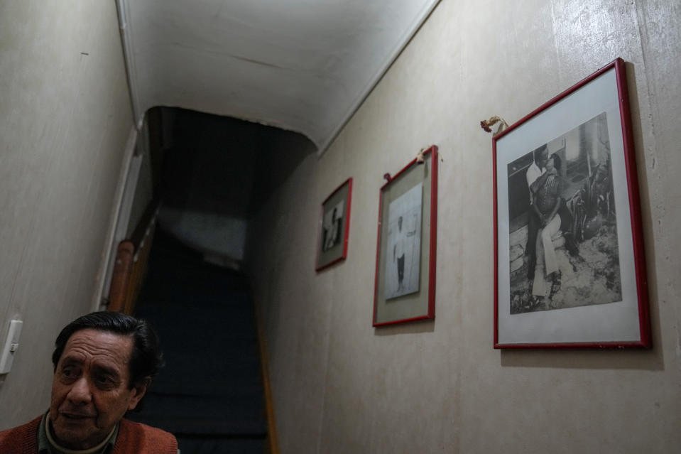 Lautaro Videla camina dentro de su casa junto a una foto de su hermana Lumi Videla besando a su esposo Sergio Pérez, en Santiago, Chile, el miércoles 2 de agosto de 2023. (AP Foto/Esteban Felix)