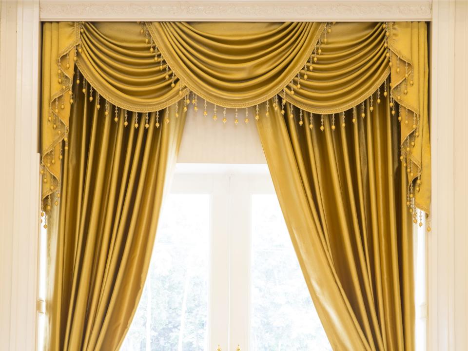 frilly draped yellow curtains window