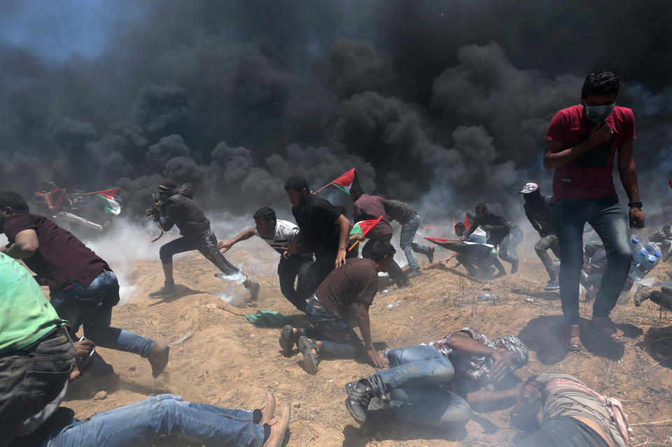 <p>Palestinian demonstrators run for cover from Israeli fire and tear gas during a protestat the Israel-Gaza border in the southern Gaza Strip against the U.S. Embassy’s move to Jerusalem, on May 14, 2018. (Photo: Ibraheem Abu Mustafa/Reuters) </p>