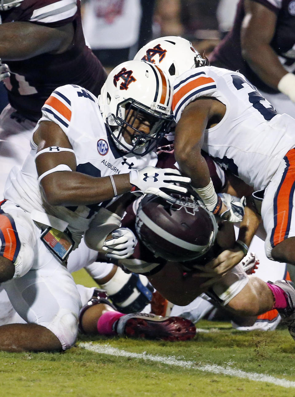 Auburn defensive backs Daniel Thomas, left, and Jeremiah Dinson, fail from keeping Mississippi State quarterback Nick Fitzgerald, underneath, from scoring on a one-yard dive into the end zone during the first half of their NCAA college football game in Starkville, Miss., Saturday, Oct. 6 2018. (AP Photo/Rogelio V. Solis)