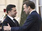 French President Emmanuel Macron, right, greets Ukrainian President Volodymyr Zelenskiy before a meeting at the Elysee Palace, Paris, France, Monday, Dec. 9, 2019. A long-awaited summit in Paris is aiming to find a way to end the war in Ukraine, after five years and 14,000 lives lost in a conflict that has emboldened the Kremlin and reshaped European geopolitics. (Alexei Nikolsky, Sputnik, Kremlin Pool Photo via AP)