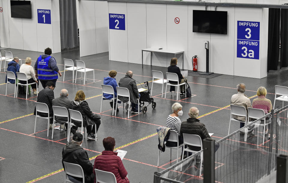 People wait at the vaccination center in Gelsenkirchen, Germany, Monday, April 26, 2021. Germany's COVID-19 vaccination program will be discussed at a meeting with Germany's state Governors and Chancellor Angela Merkel in Berlin today. (AP Photo/Martin Meissner)