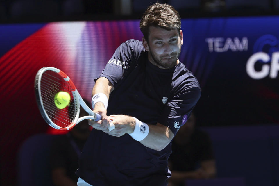 Cameron Norrie of Britain hits a backhand return to Taylor Fritz of the United States during the United Cup tennis tournament in Perth, Australia, Sunday, Dec. 31, 2023. (AP Photo/Trevor Collens)