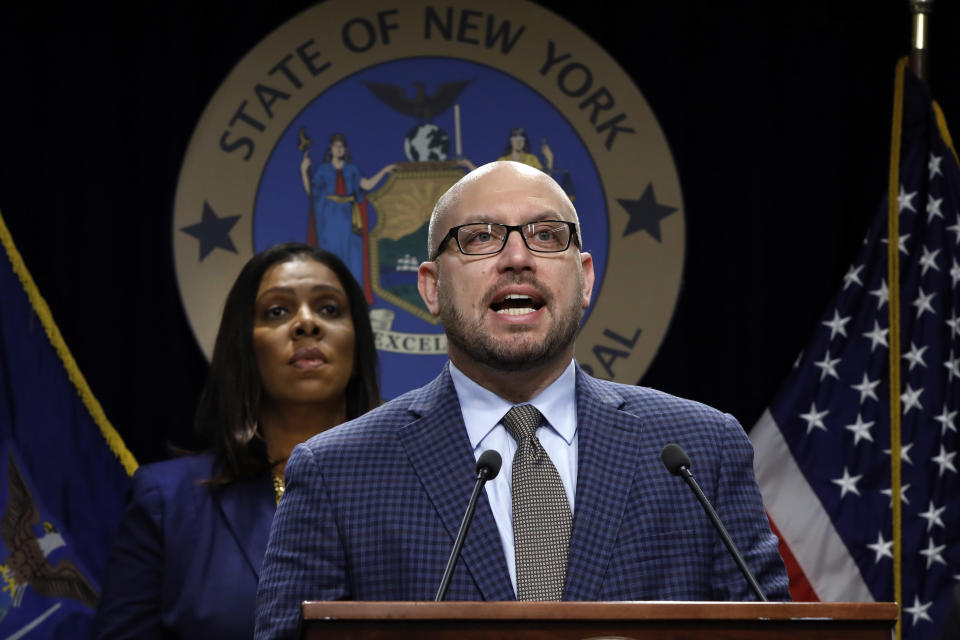 East Hampton High School Principal Adam Fine speaks as New York State Attorney General Letitia James, rear left, listens during a news conference at her office in New York, Tuesday, Nov. 19, 2019. New York has joined the ranks of states suing the nation's biggest e-cigarette maker, San Francisco based JUUL Labs. (AP Photo/Richard Drew)