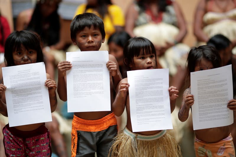 Indigenous children of the Munduruku tribe hold a letter during a press conference to ask authorities for protection for indigenous land and cultural rights in Brasilia